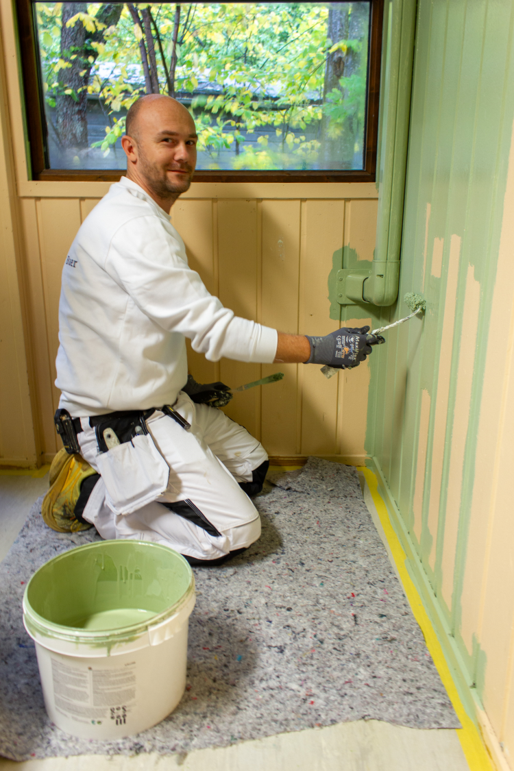 mann maler gul vegg grønn