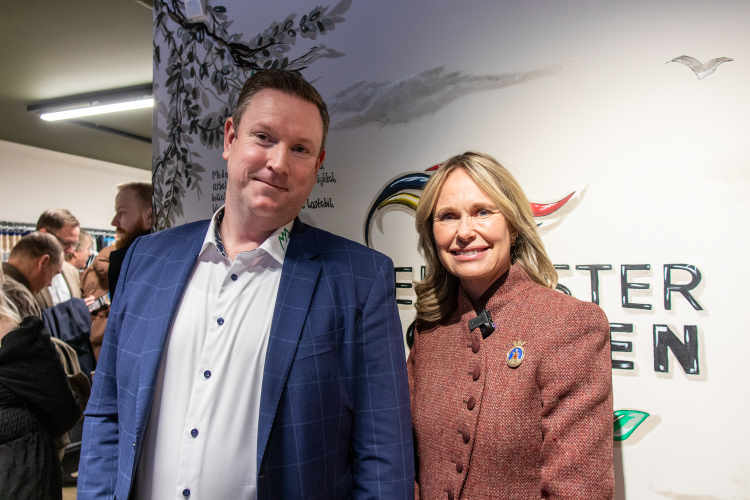 mann og dame foran vegg med logo