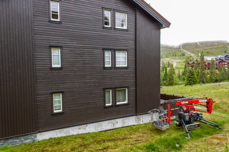 fasade på en liten leilighetsblokk med brun trekledning
