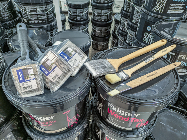 noen pensler ligger oppå et malingspann 