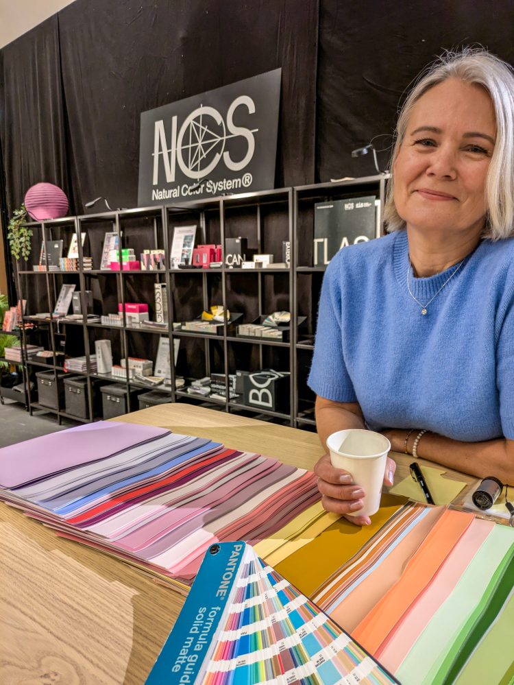 dame i blått foran vegg med sorte bøker