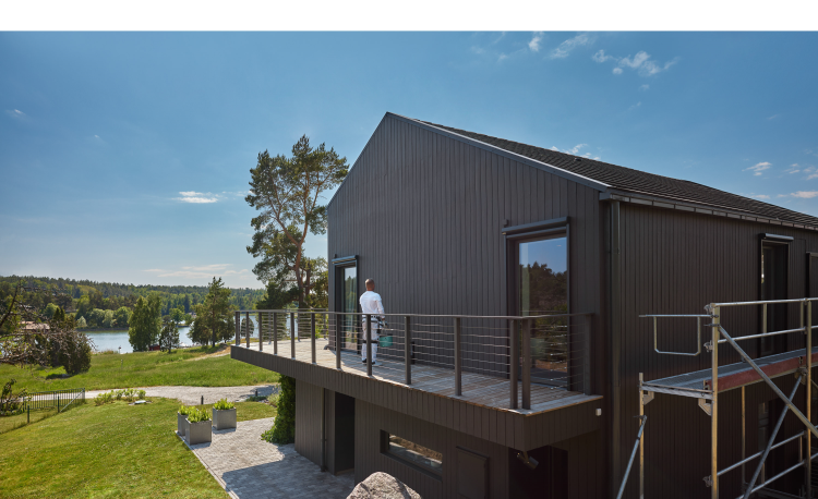 sort hus, mann som maler 