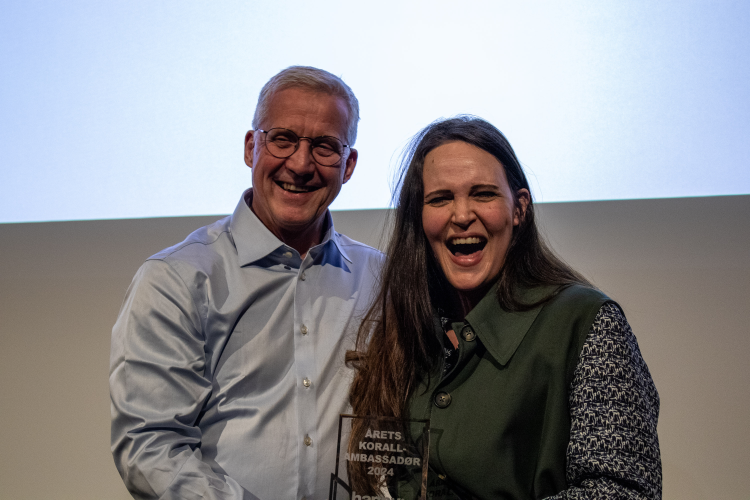 mann og dame er glade foran storskjerm 