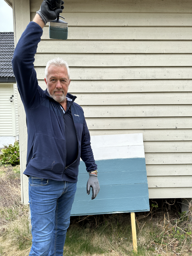 mann holder pensel med maling over hodet 