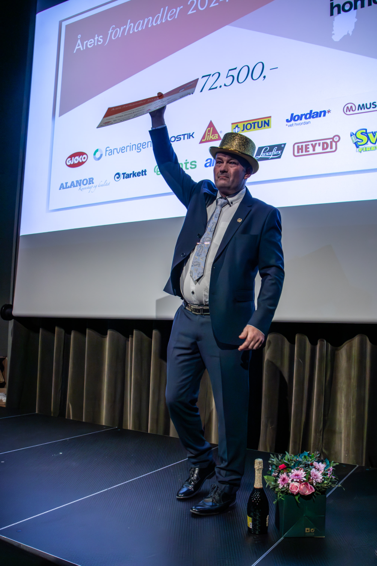 mann strekker opp armen foran stor skjerm 