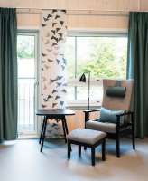 Foto: Espen Grønli<br/>Synlig yttervegg i massivt tre gir beboerrommene en lun atmosfære og er et taktilt innslag sammen med rikelig bruk av gardiner, sengeteppe og polstrede møbler.