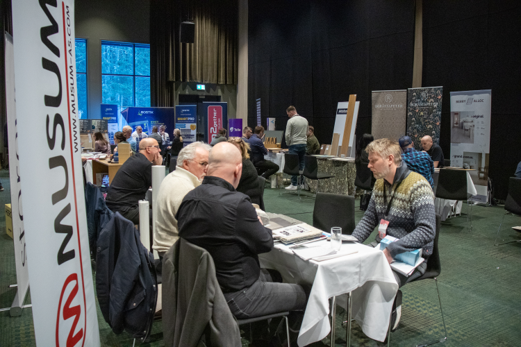 menn ved bord i stort rom med flere bord