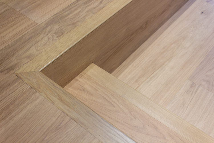 tett på bilde av nivåforskjell i gulv med herdet tre og trappeneser i samme materiale