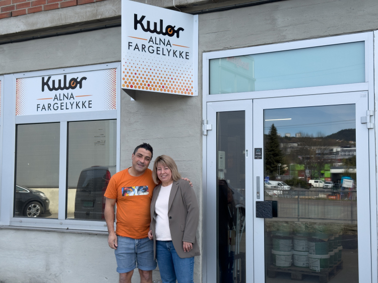 mann i oransje t-skjorte og dame i dressjakke utenfor butikkinngang