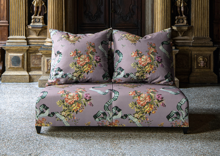 toseter sofa trukket i lilla stoff med store blomster