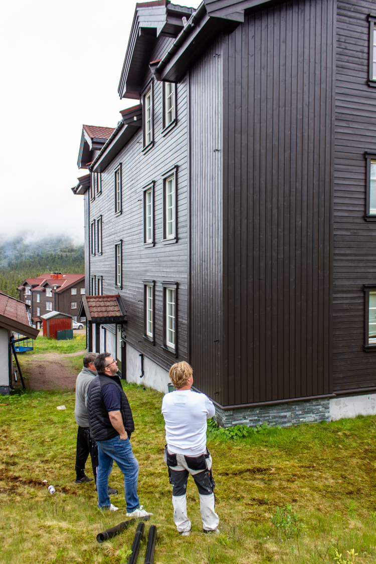 to menn foran et brunmalt hus