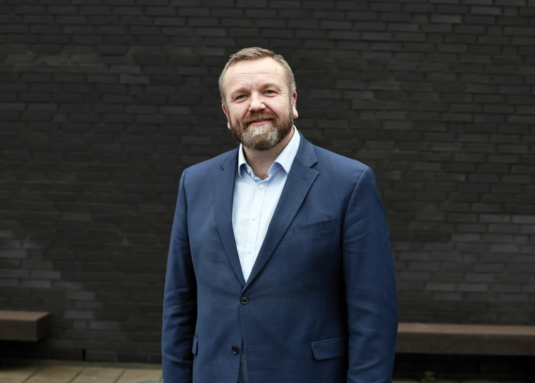 mann i mørk dress mot mørk bakgrunn