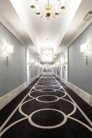 Tepper og tapet med tekstilstruktur skaper et elegant interiør, demper lyd og gir korridorene en behagelig atmosfære. <br />Foto: Kristian Owren/ifi.no