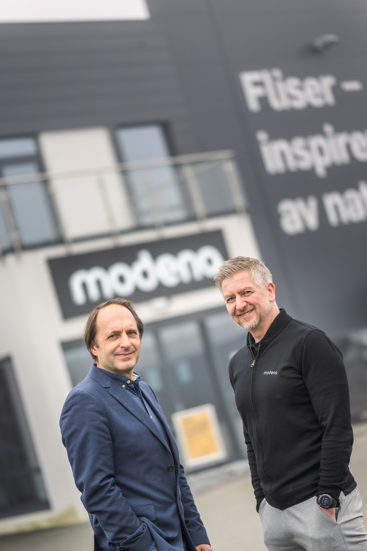 to menn foran bygg med skilt til fliskjeden Modena