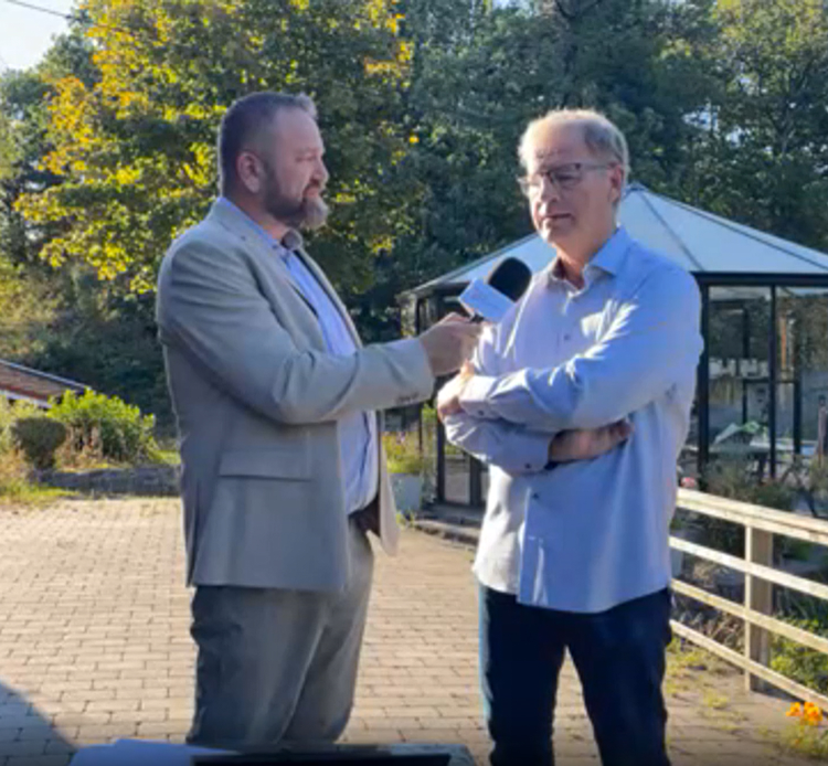 mann med mikrofon intervjuer annen nann