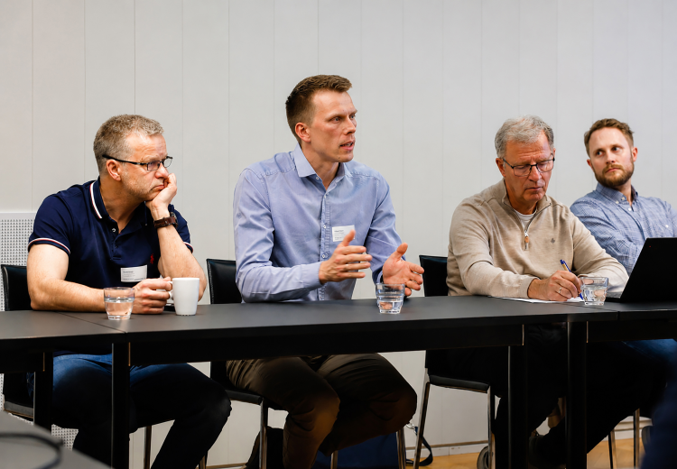tre menn ved bord i konferanse/møterom