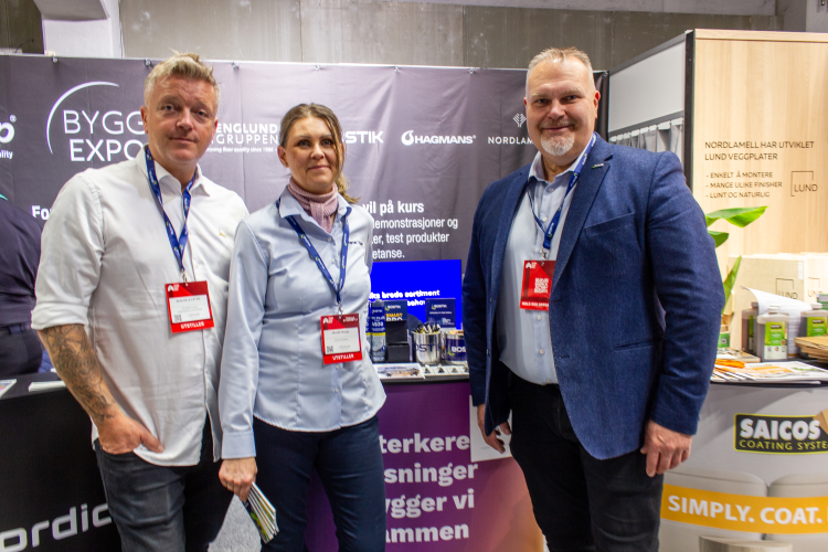 to menn med dame i midten på en stand på messe 