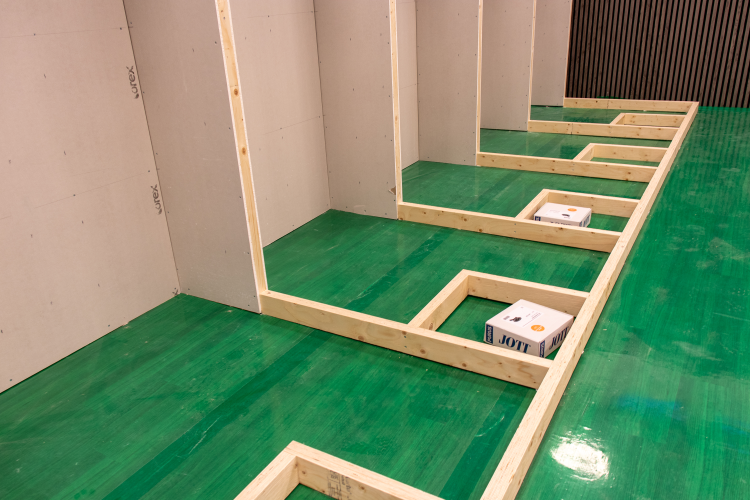 rekke med treregler bygget i båser