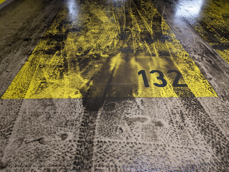 parkeringsplasser i p-hus med snøsmelt og grus på gulvet