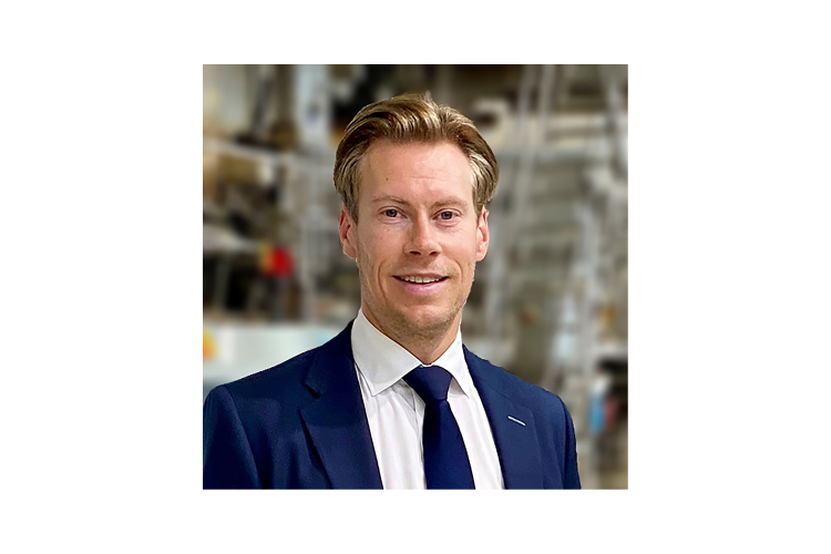 mann i dress med hvit skjorte \inne på et lager