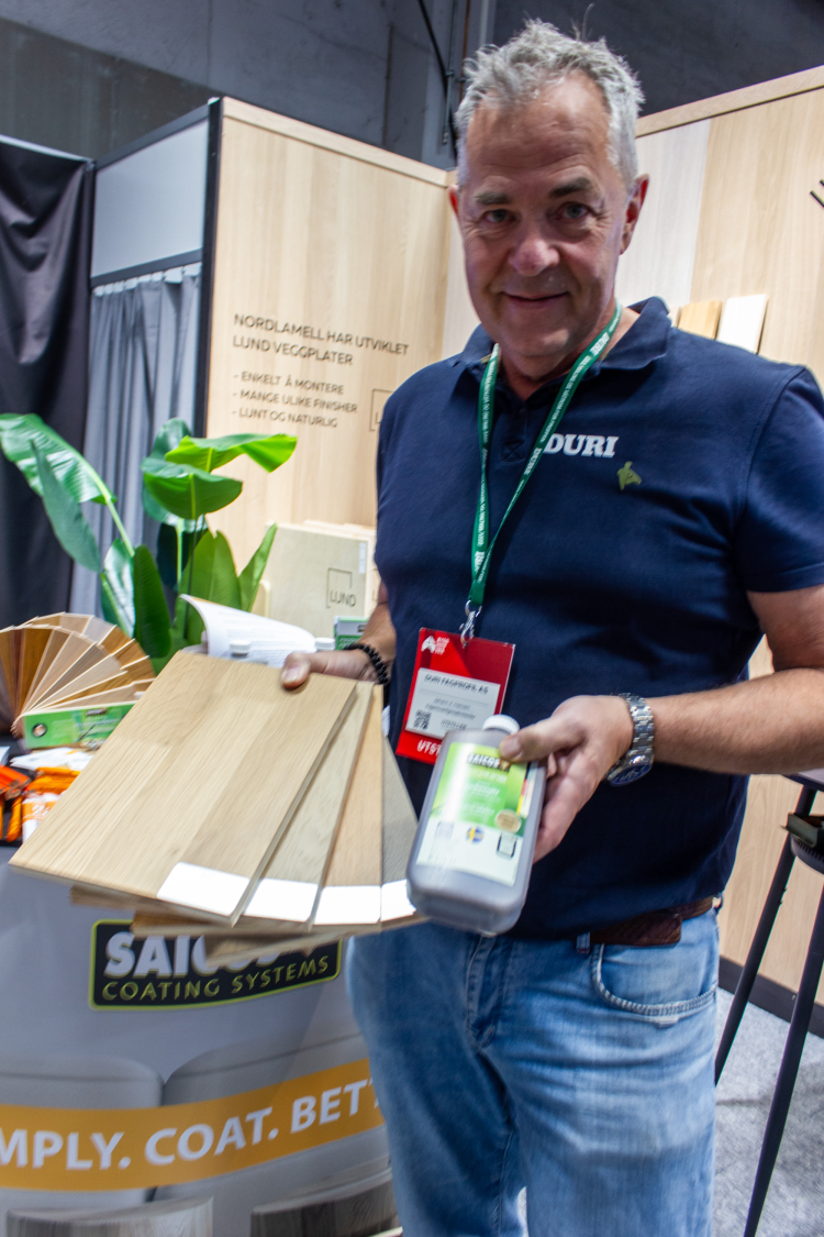 mann holder frem flaske med lakktilsats 