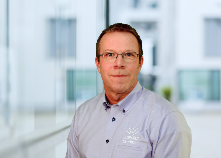 mann i blå skjorte mot lys bakgrunn