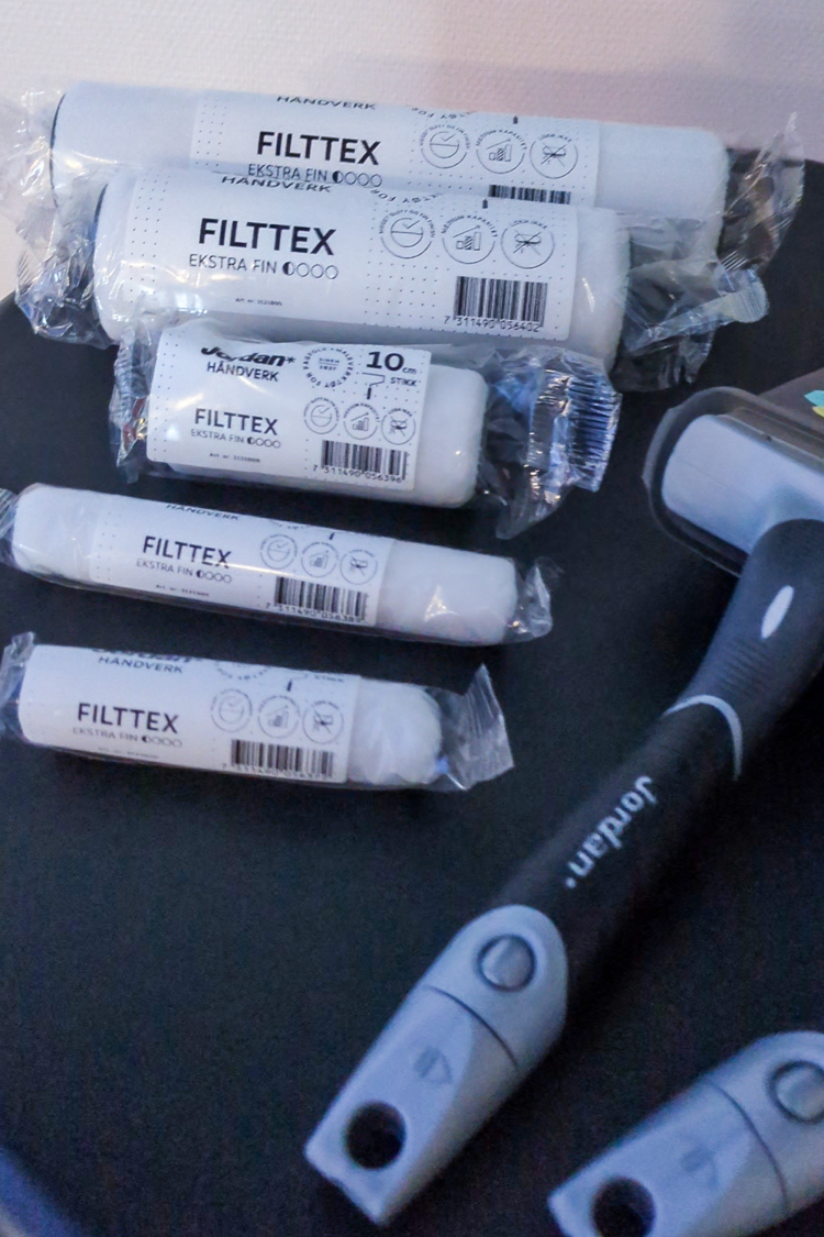 Hvite maleruller og pensler på bord