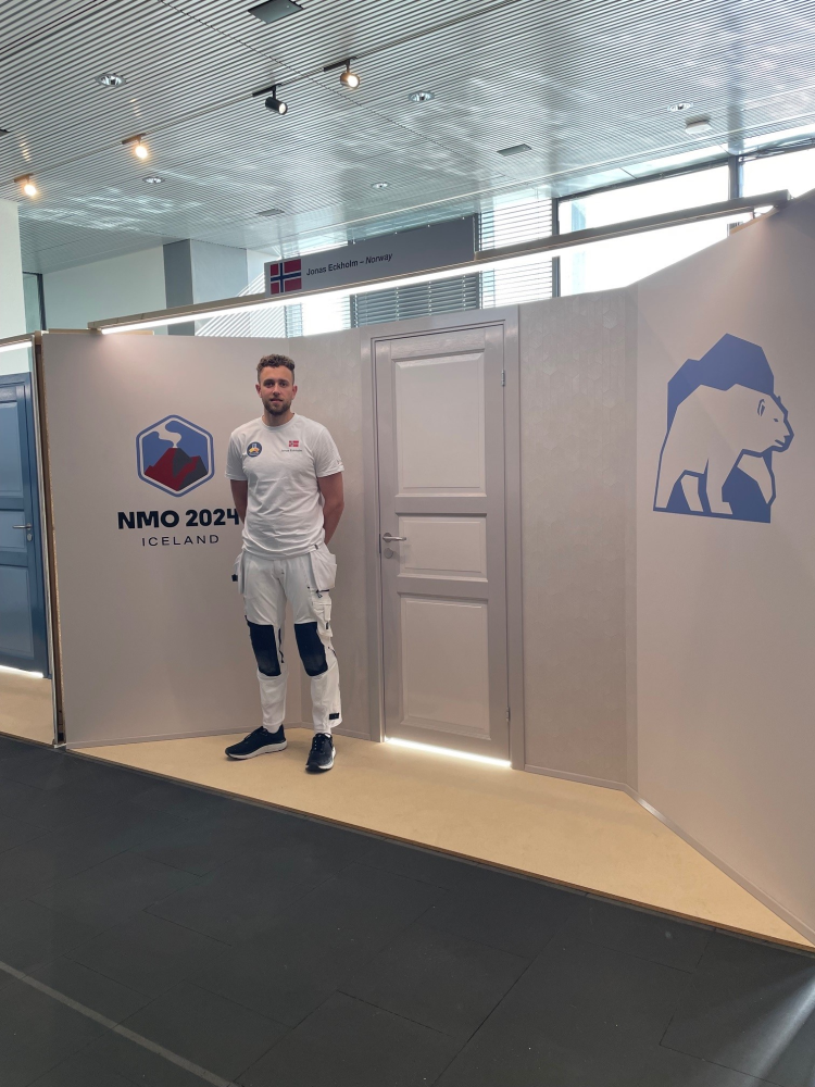 Jonas Eckholm poserer foran ferdigstilte oppgaver