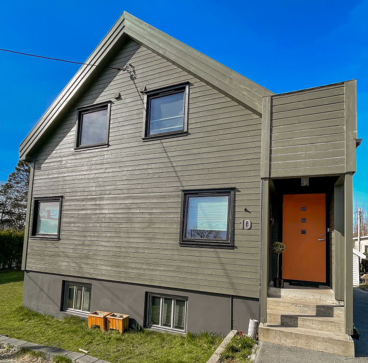 grått hus med oransje dør