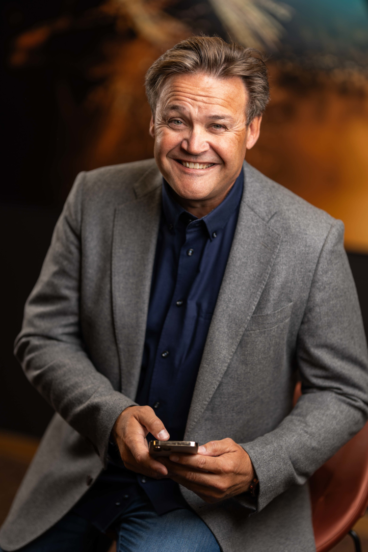 smilende mann med telefon i hånden