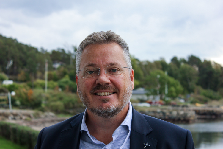 mann med hus i bakgrunnen