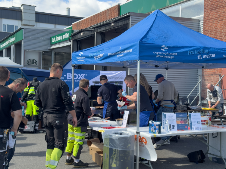 Petter Pilgaard deler ut burgere til håndverkere.