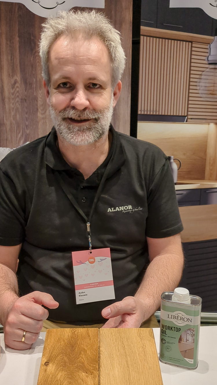 mann med sort trøye viser frem produkt for trebehandling