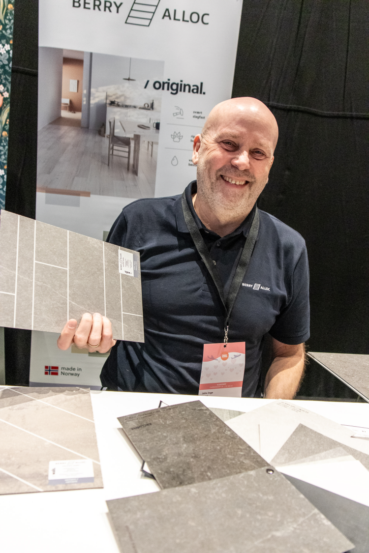 mann holder opp en plate med flisdekor