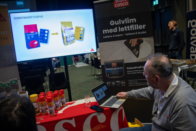 mann viser en tv-skjerm med Sika-produkter 