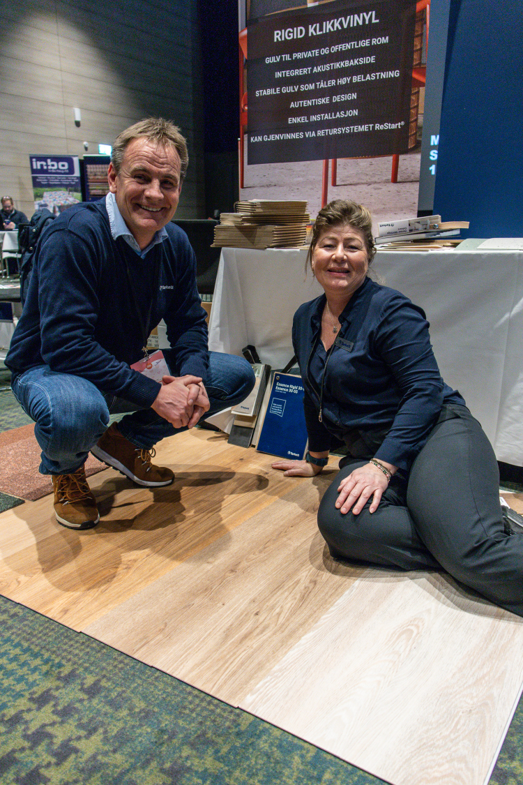 mann og dame huker seg og sitter på et trelignende gulv