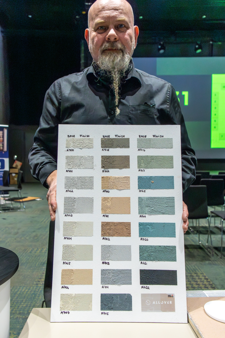 mann med flette i skjegget viser fargeprøver 
