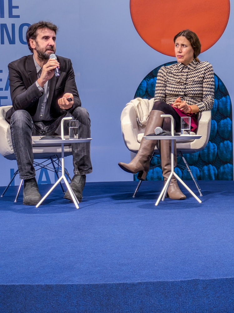 mann og dame holder presentasjon sittende i blått miljø