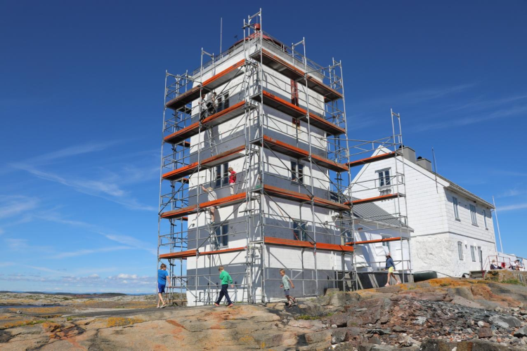 Frivillige jobber på fasaden til Fulehuk fyr.