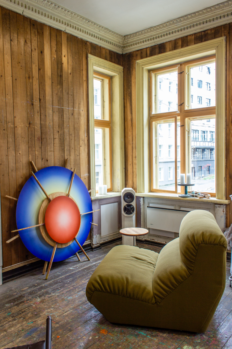 rom med grønn lenestol foran bilder og vinduer