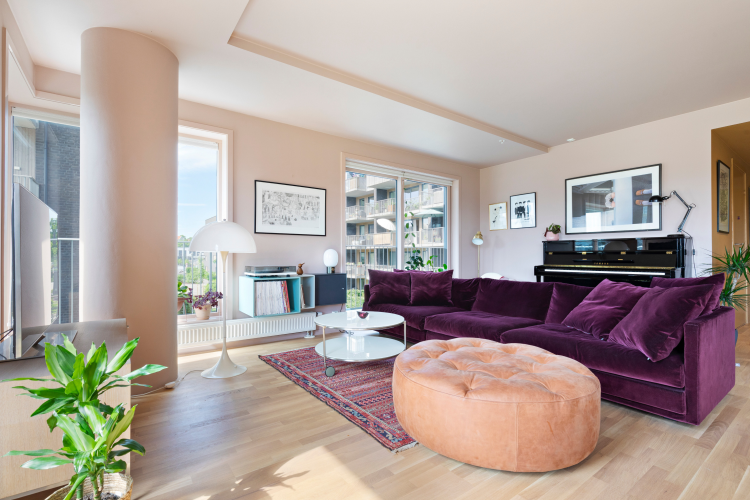 Stue med stor sofa i vinrødt mykt stoff. Vegger og tak malt med Pure&Original, farge Skin Powder.