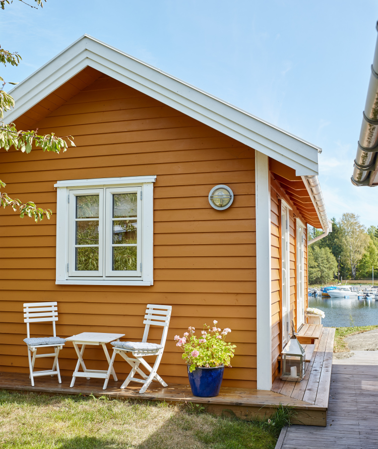 okergult lite hus tre stoler