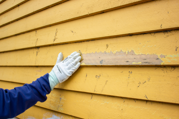 hånd på gul husvegg