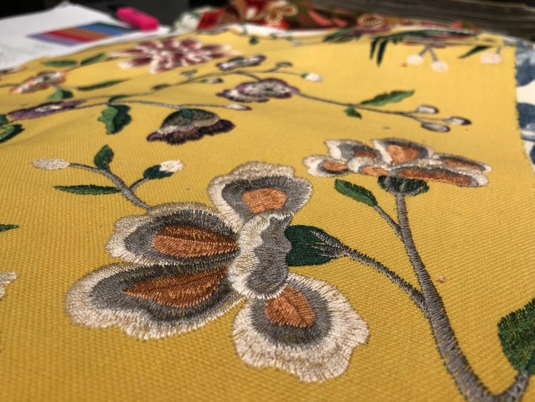 Gult tekstil med brodert blomstermotiv