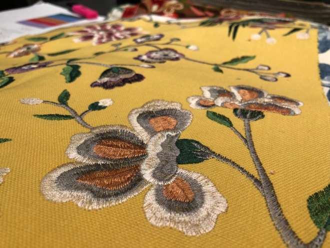 Gult tekstil med brodert blomstermotiv