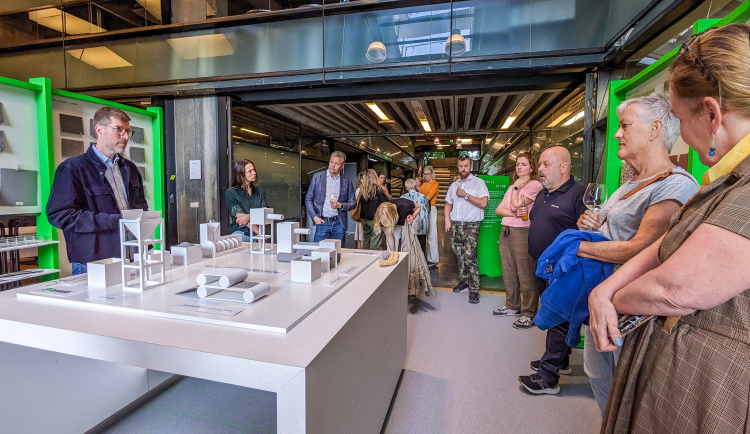 folk rundt et bord med modell av produksjonstrinn