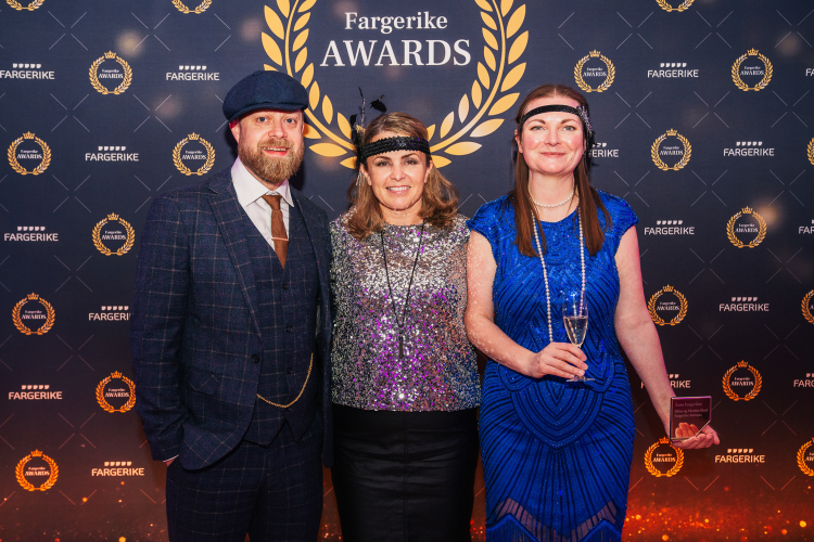 mann i rutete dress, dame i glittertopp og dame i blå kjole