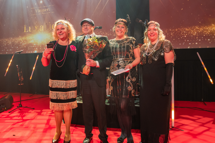 3 damer og en mann på scene