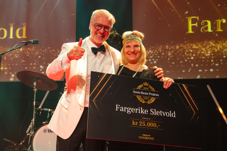 Mann i vit dressjakke med dame med hårbånd og plakat