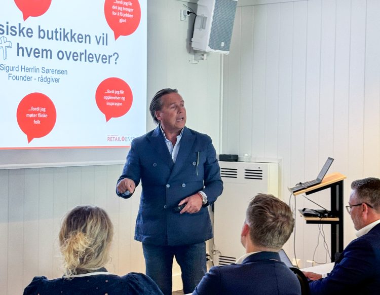 mann holder foredrag om den fysiske butikken på overhead